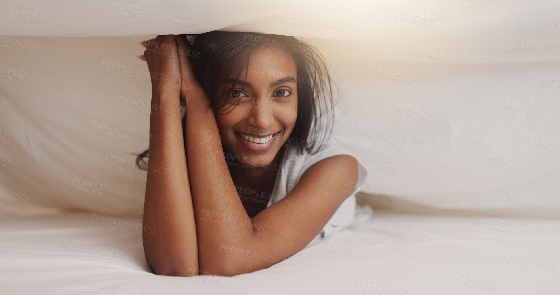 Buy stock photo Sheets, under and portrait of happy woman in bed for morning or weekend break and relaxing. Smile, hospitality and vacation with Indian person in covers in hotel or lodge for accommodation or holiday