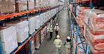 Warehouse, supplier and people walking for logistics, stock inventory or inspection by shelves. Above industrial employees, distribution and supply chain with safety, depot or wholesale storage