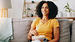 Happy woman, relax and watching tv with bowl of popcorn on sofa for online entertainment at home. Female person, user or eating with smile, snack or food for streaming show, movie or series at house