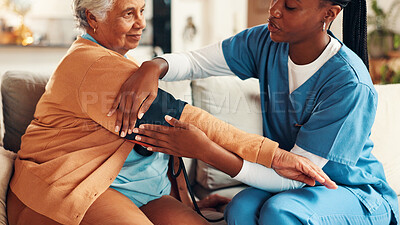 Buy stock photo Nurse, senior woman and blood pressure test on sofa with healthcare assessment for hypertension in lounge. People, caregiver and monitor for medical review, helping hand and check on couch in house