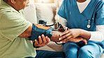 Nurse, hands and blood pressure monitor on sofa with healthcare assessment for hypertension in lounge. Senior person, caregiver and test for medical review, helping hand and check on couch in house