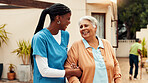 Old woman, nurse and walking outdoor at retirement home with laughing, funny conversation and rehabilitation. Happy, caregiver and senior person with mobility support, bonding together and fresh air