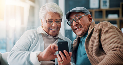Buy stock photo Senior couple, phone and laugh on couch in home with meme, mobile app and funny video on web in lounge. Elderly man, woman and relax with smartphone, joke and social media in retirement at apartment