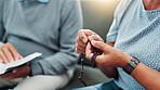 Hands, rosary and couple praying with bible in home for religious study, spiritual faith or crucifix meditation. Old people, worship or holy necklace on sofa with scripture guidance or trust in Jesus