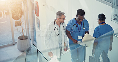 Buy stock photo Discussion, doctor and nurse walk on stairs with documents in hospital lobby. Above conversation, medical professional men on steps with paperwork for healthcare, teamwork or collaboration in clinic