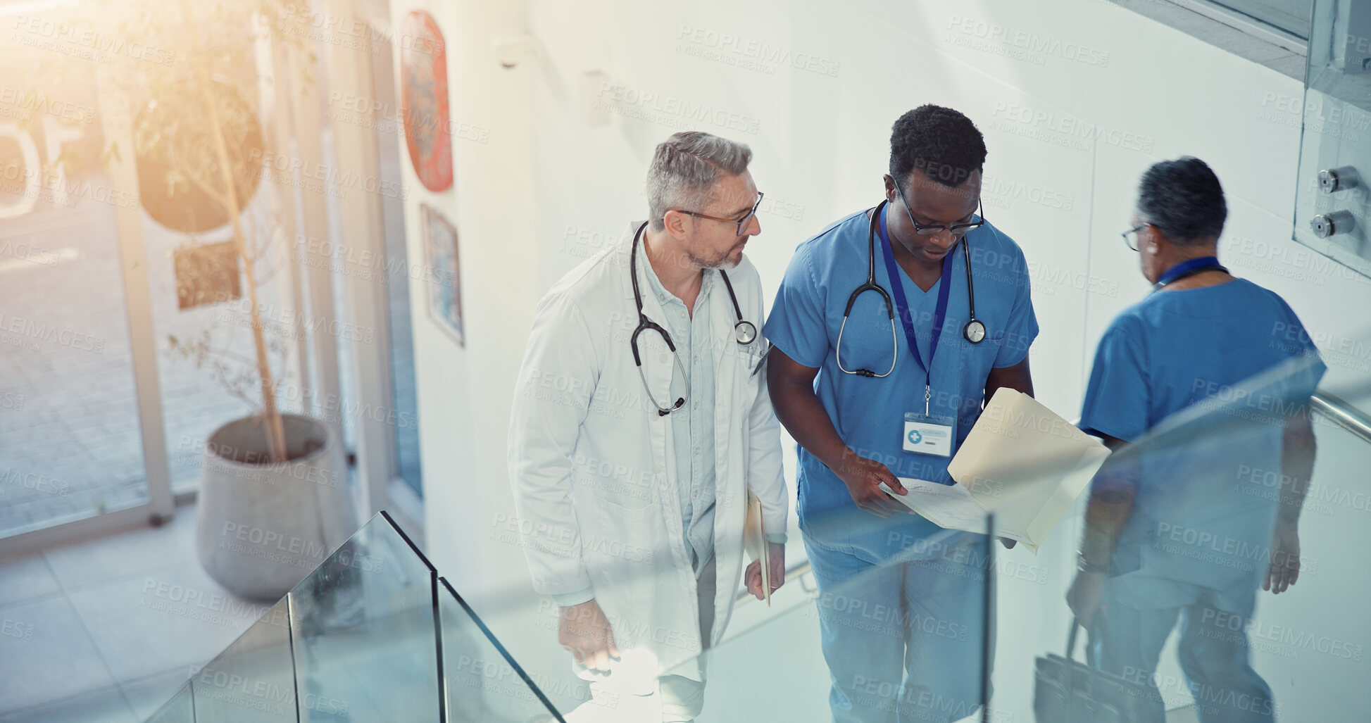 Buy stock photo Discussion, doctor and nurse walk on stairs with documents in hospital lobby. Above conversation, medical professional men on steps with paperwork for healthcare, teamwork or collaboration in clinic