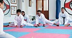 Kids, sensei and stretching in karate class for preparation, start lesson or warm up for martial arts. Girls, boys and coach and students in dojo ready for self defense training, taekwondo and sports