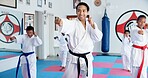 Sensei, punch and man with kids in karate class, self defense training or martial arts with youth for combat education. Taekwondo, fight and male instructor with student children coaching in dojo