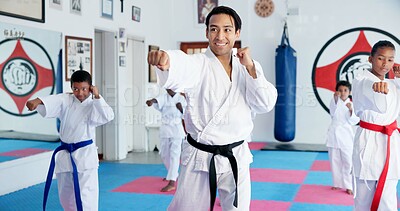 Buy stock photo Sensei, punch and man with kids in karate class, self defense training or martial arts with youth for combat education. Taekwondo, fight and male instructor with student children coaching in dojo