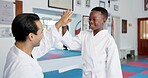 Boy, teacher and high five with smile in dojo for martial arts training, self defense or fighting competition. Child, student and celebration with support for taekwondo challenge or community karate
