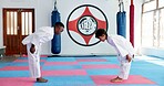 Bow, respect and kids in karate dojo for self defense training, tradition or custom with martial arts. Boys, students and prepare for fight, discipline and taekwondo with fitness or combat sports