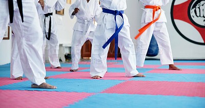 Buy stock photo Karate, kids and legs at dojo for fighting, self defense or fitness training together. Practice, children and body of students with kicking exercise for martial arts, workout or aikido lesson at gym.