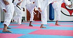 Karate, children and legs at dojo for fighting, self defense or fitness training together. Practice, kids and body of students with kicking exercise for martial arts, workout or aikido lesson at gym.