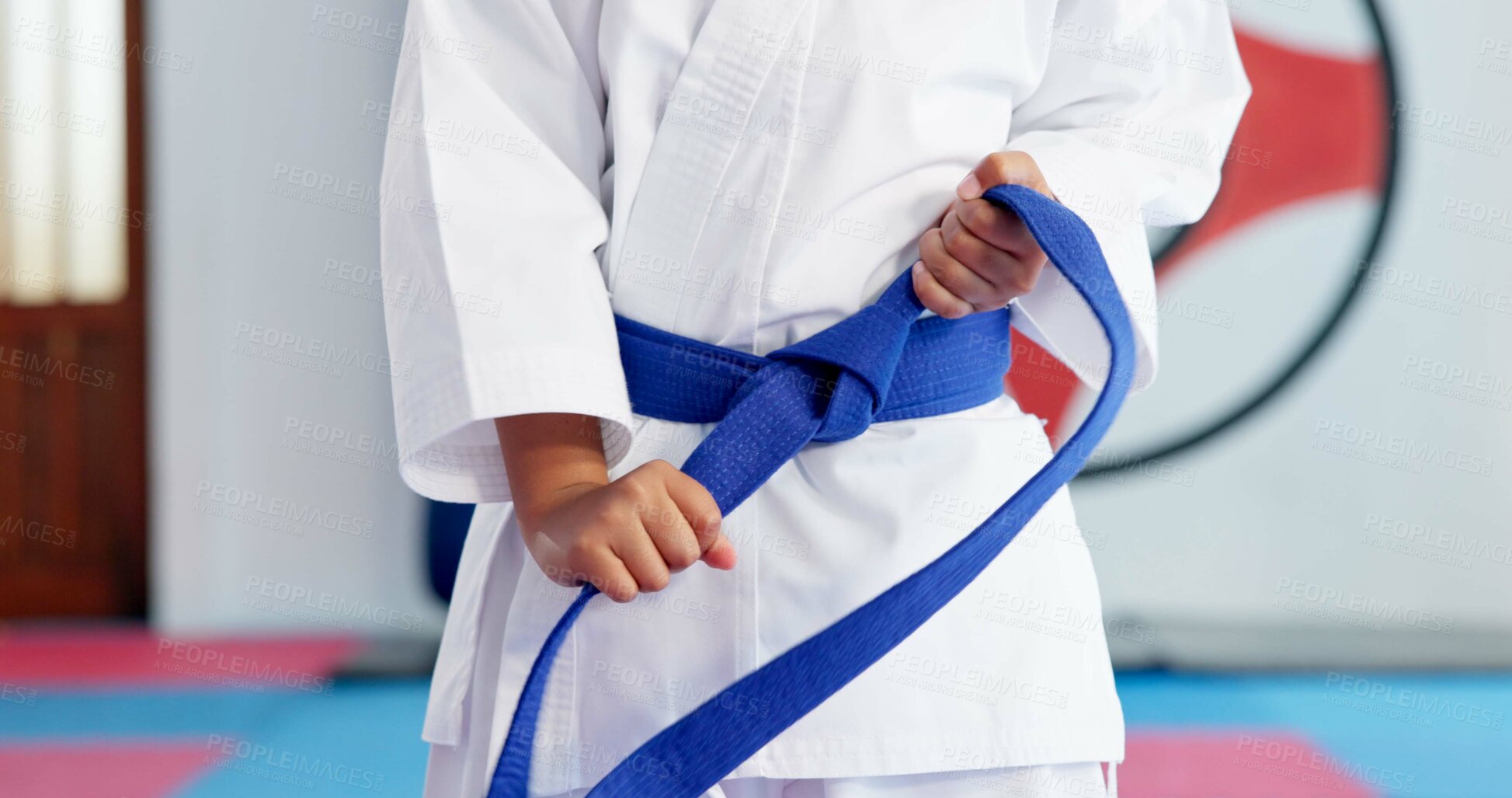 Buy stock photo Hands, blue belt and kid in karate dojo for self defense training, skill level or martial arts. Child, student and prepare for fight, tying knot for experience and taekwondo with growth or sports