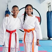 Hug, karate and portrait of students in dojo for martial arts, self ...