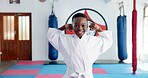 Arms, karate and portrait of boy student in dojo for combat, martial arts or sports training. Exercise, fitness and flexing biceps with happy African child in gym for education, development or growth