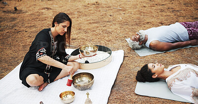 Buy stock photo Meditation, sound therapy and people with bowls in nature for mindfulness, spiritual cleanse and zen energy. Wellness, morning ritual and woman with vibration for healing, balance and chakra outdoor