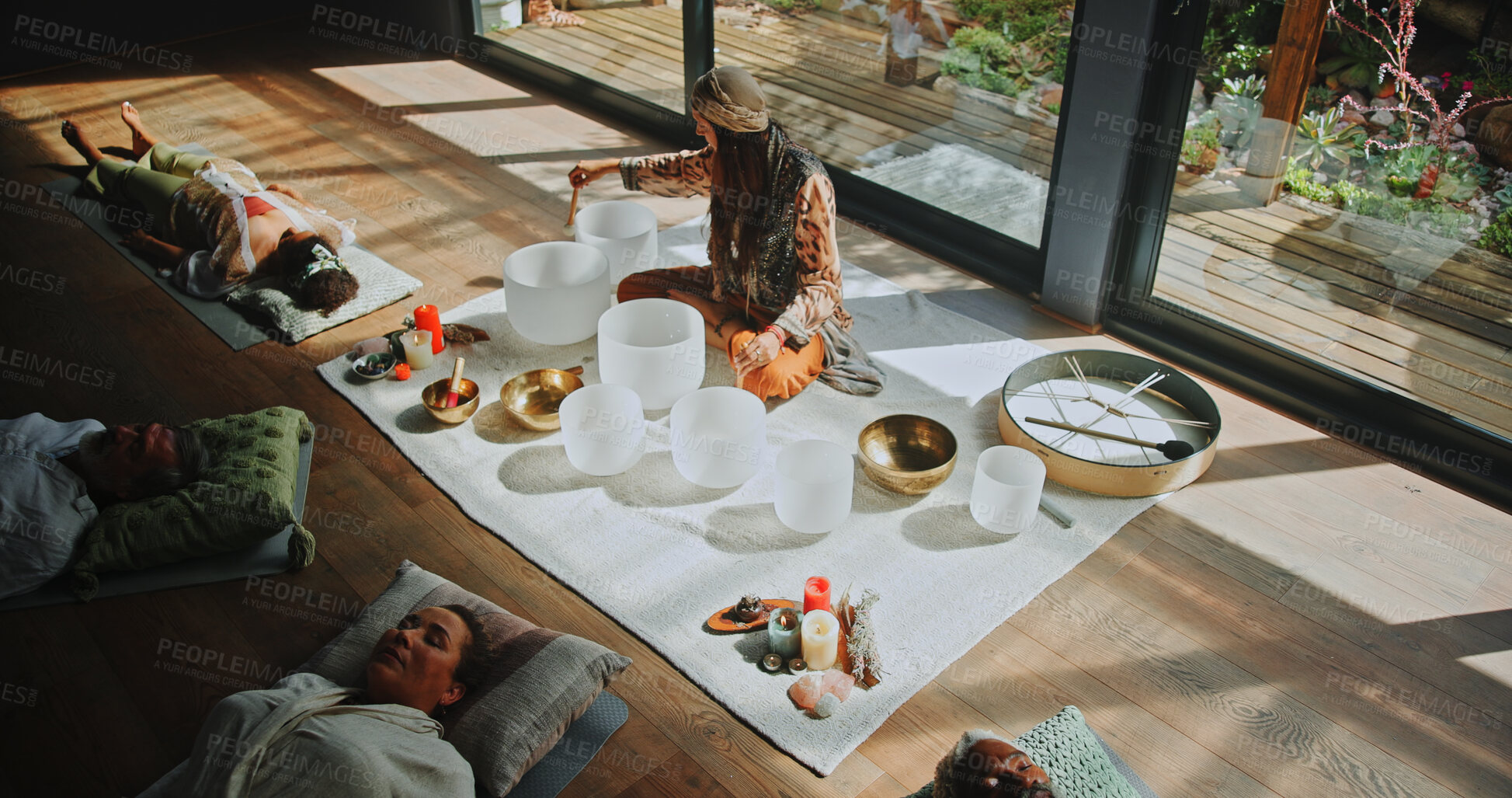 Buy stock photo Woman, singing bowl and group on floor with healing, sound therapy or lying with mindfulness at studio. Person, shaman and guide for holistic class with people, crystal or zen for chakra balance