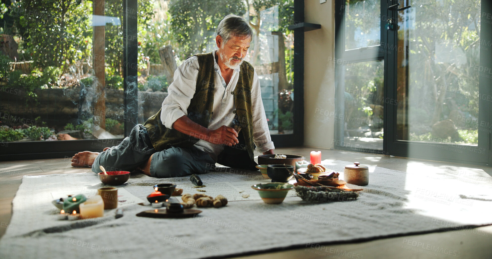 Buy stock photo Floor, alternative medicine and Asian man for holistic treatment, spiritual meditation and healing. Aromatherapy, incense and healer with crystal stones for peace, chakra and detox for wellness