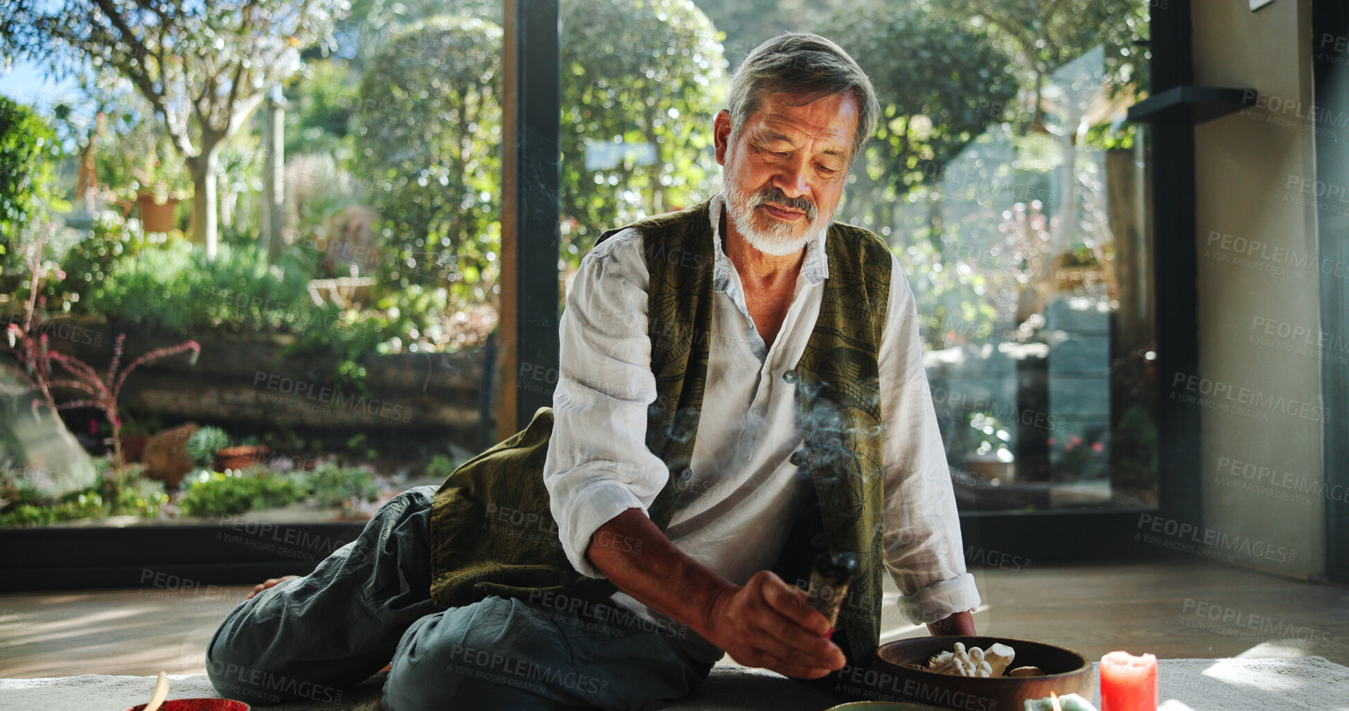 Buy stock photo Healing, smoke and holistic with asian man and incense for spiritual retreat, self care ritual and burning herbs. Aromatherapy, mindfulness and wellness ceremony with senior person for aura cleanse