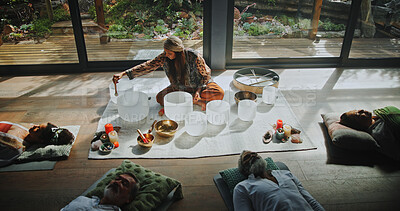 Buy stock photo Woman, singing bowls and group on floor with sound, therapy or lying with mindfulness at studio. Person, shaman and guide for class with people, crystal or zen for chakra balance for holistic healing