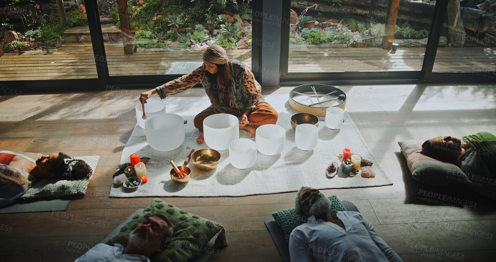 Buy stock photo Woman, singing bowls and group on floor with sound, therapy or lying with mindfulness at studio. Person, shaman and guide for class with people, crystal or zen for chakra balance for holistic healing