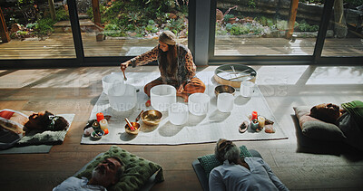 Buy stock photo Woman, singing bowl and group on floor for sound, therapy or lying with mindfulness at studio. Person, homeopath and guide at class with crystal, above and zen for chakra balance for holistic healing