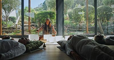 Buy stock photo Woman, singing bowl and floor for holistic therapy, frequency and peace with mindfulness at studio. Group, shaman and healing with guide in class, crystal or zen for chakra balance at wellness resort