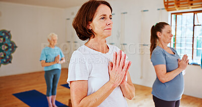 Buy stock photo Breathing, namaste and women in group meditation for calm mindset, zen or peace in mental wellness. Posture, morning and mature people in class together for mindfulness, relax or holistic self care.