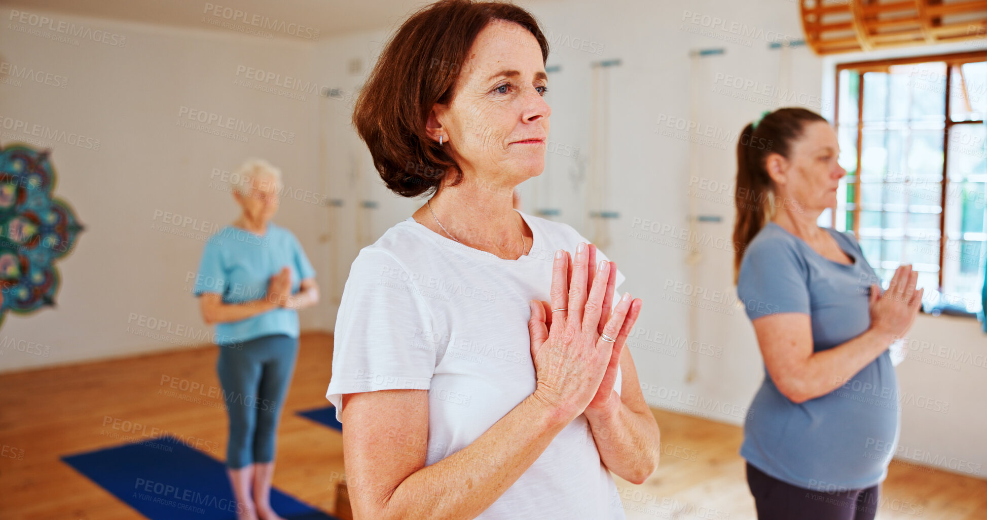 Buy stock photo Breathing, namaste and women in group meditation for calm mindset, zen or peace in mental wellness. Posture, morning and mature people in class together for mindfulness, relax or holistic self care.