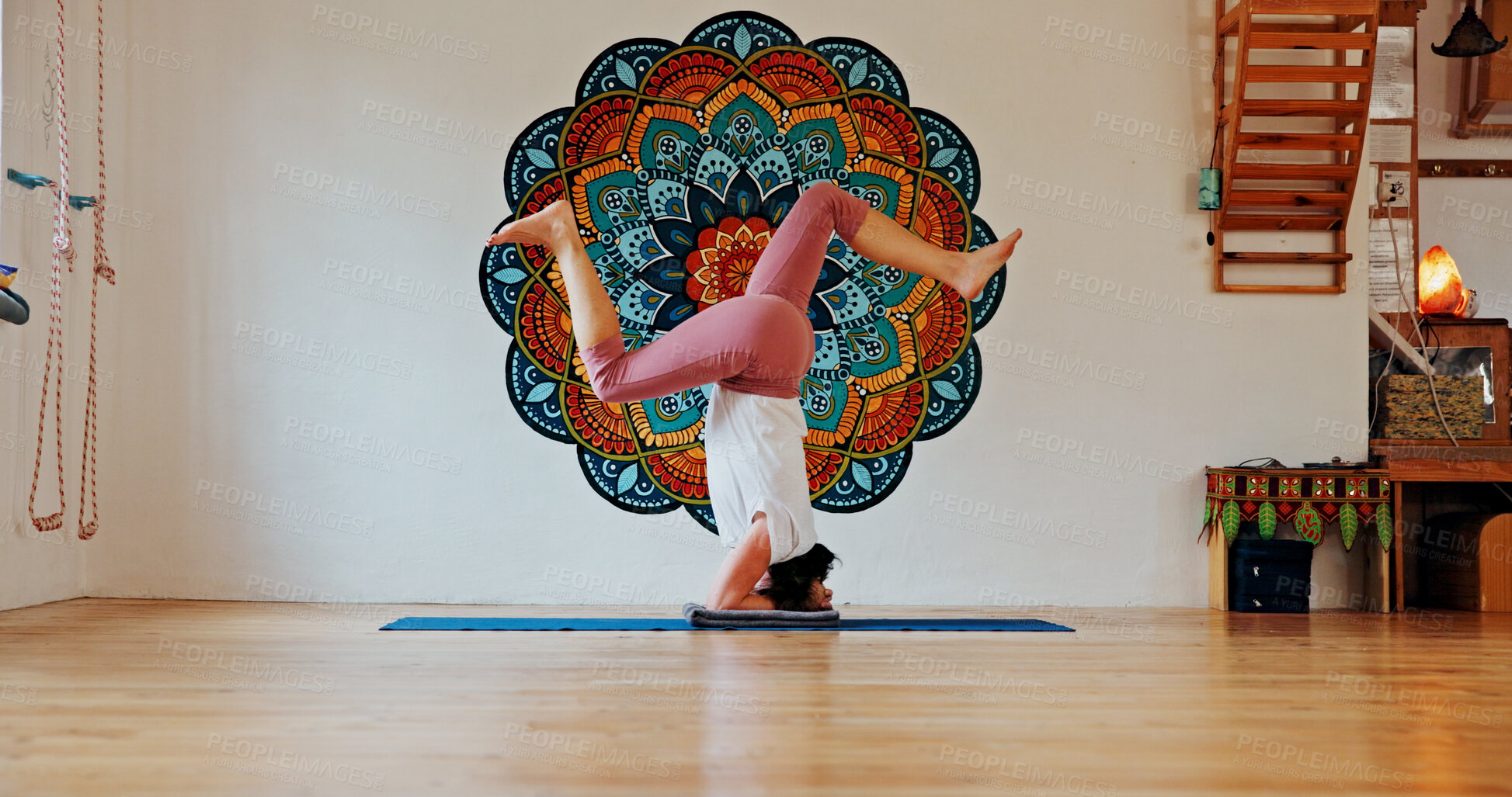 Buy stock photo Balance, upside down or yoga and woman in class with wall art for fitness or wellness routine. Exercise, headstand or pilates and yogi person in studio with mandala symbol for holistic health