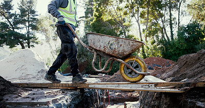 Buy stock photo Person, wheelbarrow and materials at construction site outdoor, cement and concrete mixing. Male contractor, builder and transport tools for gravel, soil and renovation items at industrial excavation