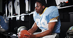 Thinking, black man and player for football in locker room for preparation, sports match and game plan. Athlete, waiting and half time for competition ideas, fitness challenge and  tournament choice
