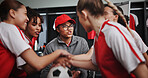 Women, coach and hands together with soccer team for motivation or collaboration in locker room. Female people, group or sport players piling with stack or ball in huddle for game plan or match