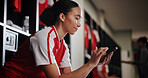 Phone, woman and athlete in locker room for training, match or game with scrolling on social media. Happy, relax and female soccer player with cellphone for networking on mobile app in changing area.