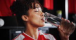 Girl, soccer player and drinking water with bottle in locker room for hydration, break or half time. Female person, athlete or thirst with refreshing mineral liquid for natural sustainability or rest