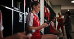 Cellphone, woman and athlete in locker room for game, match or practice with scrolling on social media. Tech, relax and female soccer player with phone for networking on mobile app in changing area.