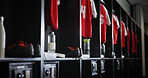 Empty, soccer equipment or locker room with gear for sport, fitness or training center. Row, line or aisle with clothing, water bottle or safe for fitting facility, interior or fashion of sportswear