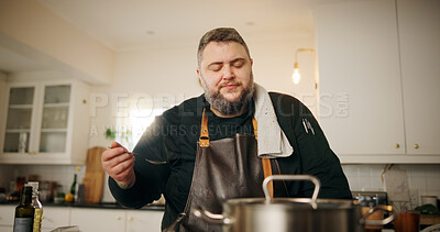 Buy stock photo Chef, taste and man in kitchen, cooking and recipe with culinary skills, meal prep or healthy lunch. Home, person or expert with utensils, inspection or check flavor with sample, nutrition or cuisine