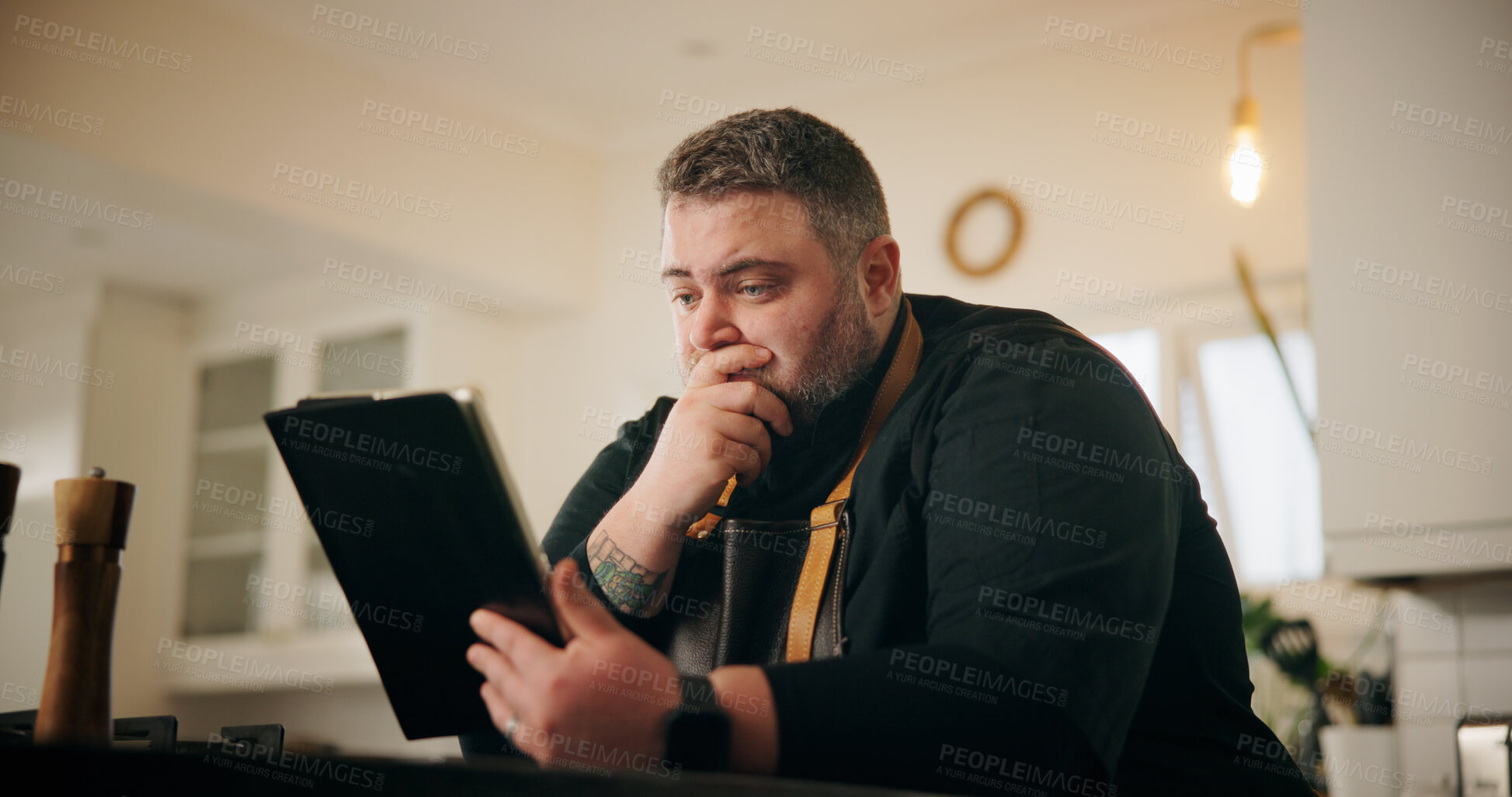 Buy stock photo Tablet, stress and chef in kitchen for online recipe planning, instructions or research for cook book. Shock, digital technology and male person reading negative culinary review on restaurant in home