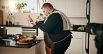 Man, chef and recording in kitchen with food, dinner or recipe online for content creation. Camera, cooking and influencer person with equipment for live streaming, diet advice and meal in home