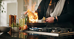 Cooking, flame and man with hands, home and frying pan with fire, wellness and ingredients. Closeup, person and chef with utensils, heat and meal prep with nutrition, culinary skills or flambe expert