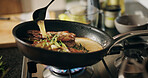 Cooking, stove and steak in pan with sauce in kitchen for culinary skill, recipe and meal prep for dinner. Food, chef and person with beef, meat and seasoning for gourmet dish, ingredients or cuisine