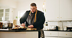 Man, chef and cutting in kitchen with food for meal prep, dinner or private catering service at home. Male person, culinary artist or chopping board with stove for hospitality, recipe or ingredients