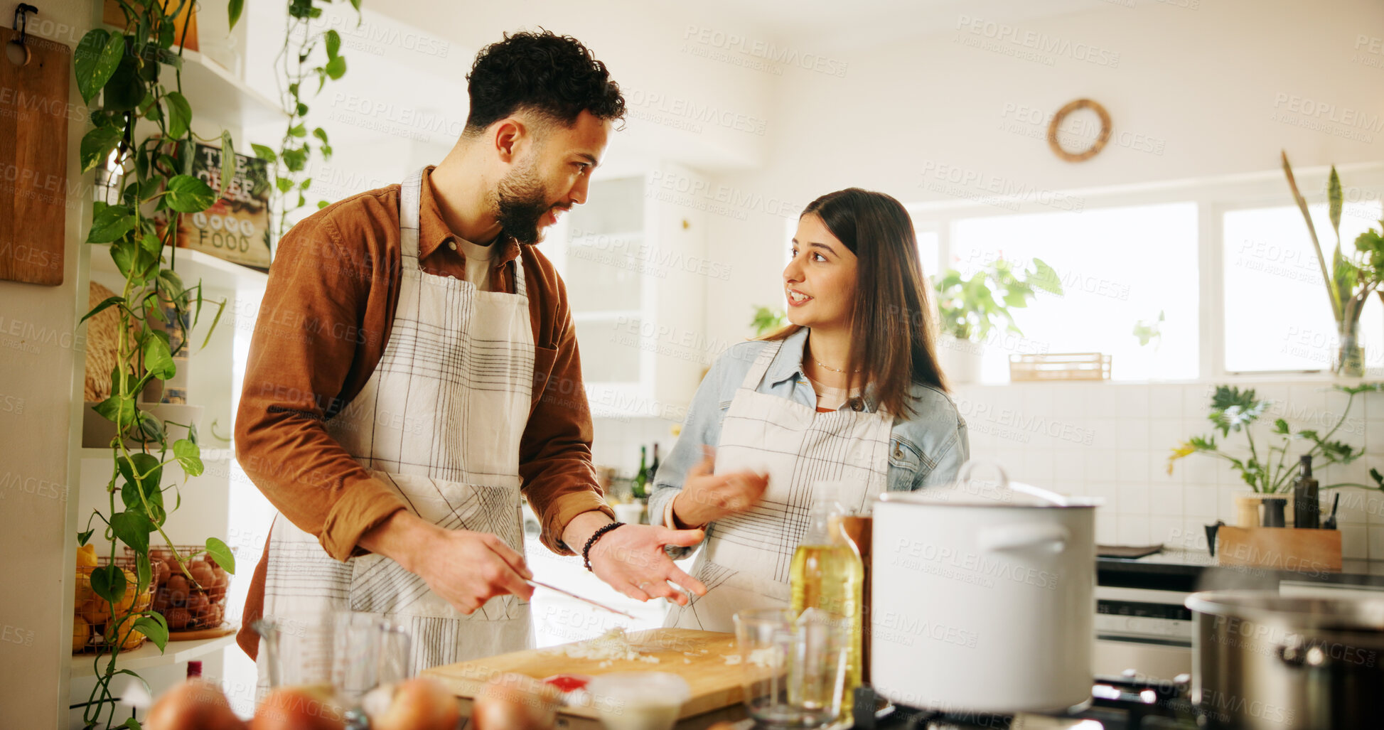 Buy stock photo Cooking, couple and happy with ingredients in kitchen for recipe guidance, meal preparation and support. Nutrition, people and talking in home with cutting vegetables, healthy dinner and helping hand
