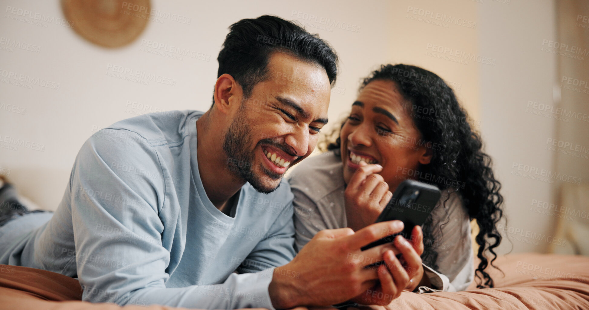 Buy stock photo Happy couple, relax or laughing with phone on bed for online entertainment, humor or comedy at home. Man, woman or lovers with smile on mobile smartphone for movie or subscription in bedroom at house