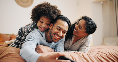 Buy stock photo Bedroom, family and bonding with child, smartphone and watching movies on website, entertainment and online. Parents, woman and man with son in home, streaming and smile for comedy film in apartment