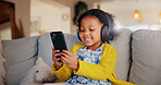 Phone, headphones and happy child in home for online learning, music and play game for education. Girl, audio and kid with mobile in living room for internet app, streaming cartoon and watch video