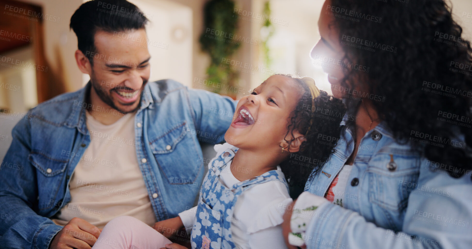 Buy stock photo Parents, girl and tickle on sofa, happy and bonding with love, joke and relax in lounge at family house. People, mother and father with child, care and funny game with laughing in living room at home