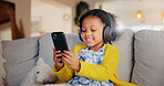 Mobile, headphones and happy child on sofa for music, online learning or play game for education. Girl, audio and kid with phone in home living room for internet app, streaming cartoon or watch video